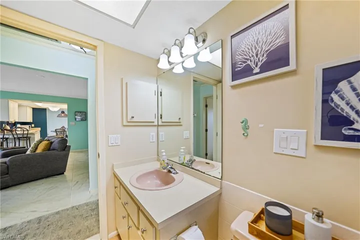 Bathroom with vanity, a chandelier, and light marble finish floors