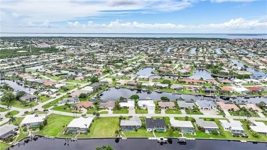 Aerial overview of property's location with a nearby body of water and nearby suburban area