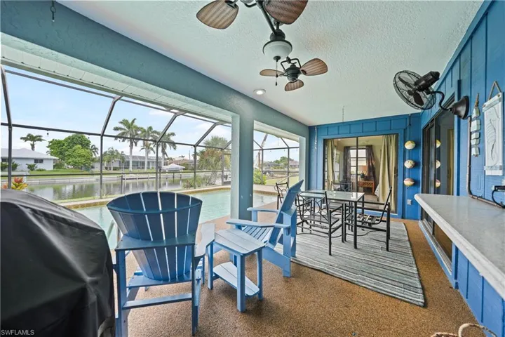 Sunroom featuring a water view, ceiling fan, a patio, and outdoor dining area