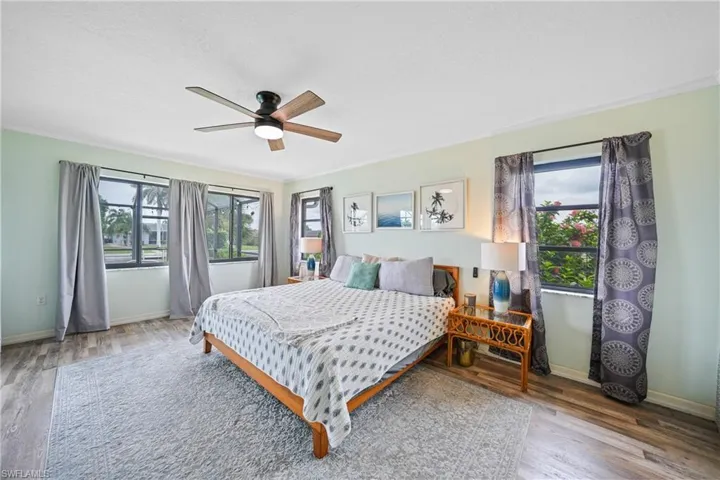 Bedroom with wood finished floors, a ceiling fan, and ornamental molding