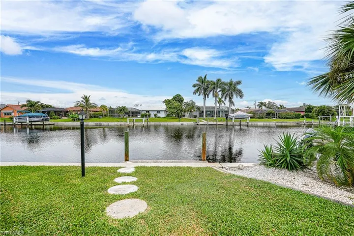 Water view featuring nearby suburban area and a dock