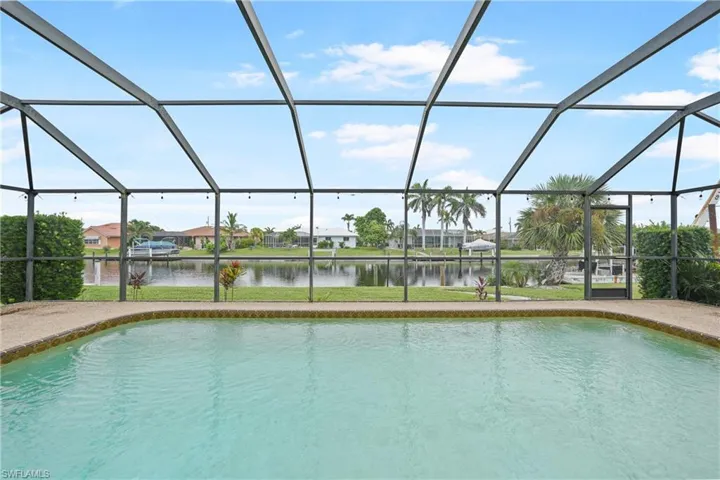 Swimming pool with a sunroom, a residential view, a water view, and a lanai