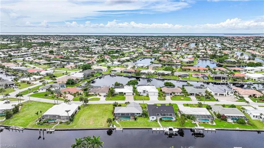 Aerial perspective of suburban area featuring a nearby body of water