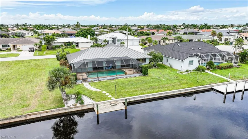 Rear view of property with a residential view, a sunroom, glass enclosure, and a water view