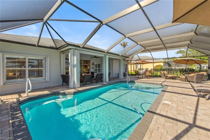 Outdoor pool with a lanai, outdoor lounge area, and a patio area