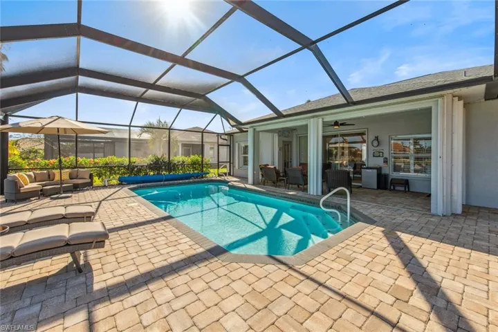 View of swimming pool featuring a covered pool, a lanai, an outdoor living space, a ceiling fan, and a patio area