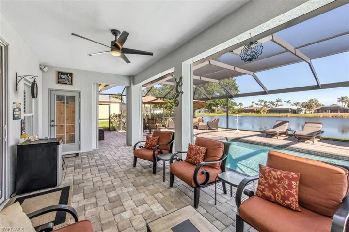 Sunroom / solarium with a ceiling fan and a water view
