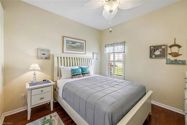 Bedroom featuring dark wood-style floors, ceiling fan, and baseboards