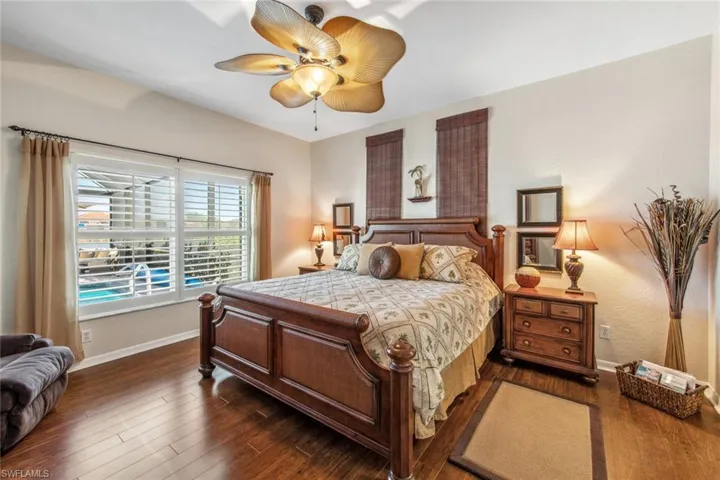 Bedroom featuring dark wood-type flooring, baseboards, and a ceiling fan