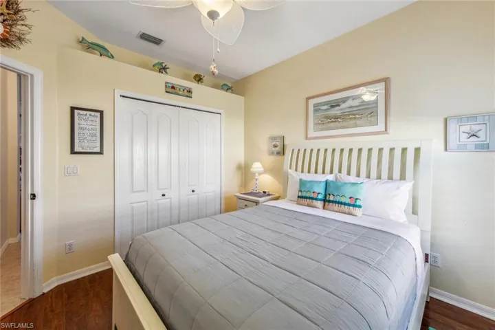Bedroom with baseboards, visible vents, a closet, and dark wood-type flooring