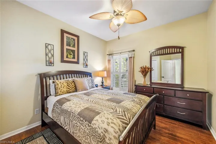 Bedroom featuring a ceiling fan, dark wood-style floors, and baseboards