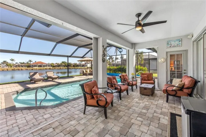 Pool featuring a water view, a ceiling fan, a lanai, and a patio area