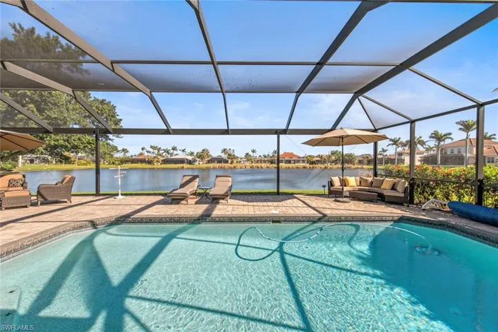 Pool with an outdoor living space, a lanai, a water view, and a patio