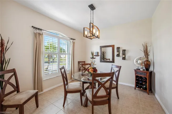 Dining area with an inviting chandelier, light tile patterned floors, and baseboards