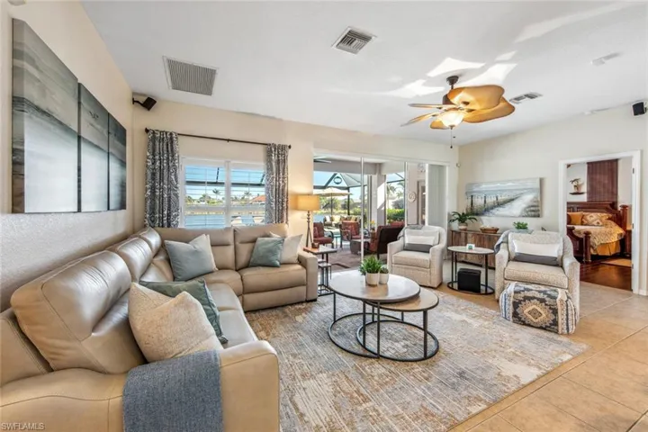 Living room with a ceiling fan, visible vents, and light tile patterned floors