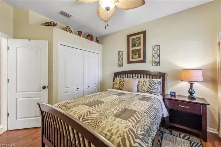 Bedroom featuring visible vents, a closet, wood finished floors, and ceiling fan