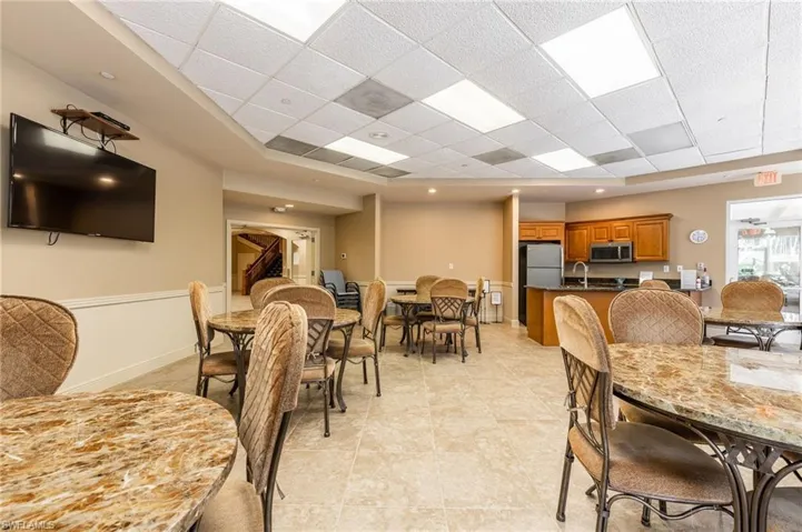Dining room with baseboards, light tile patterned floors, and a paneled ceiling