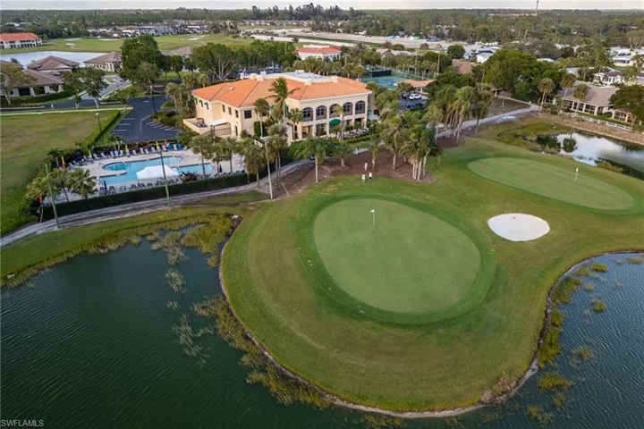 Birds eye view of property with golf course view and a water view