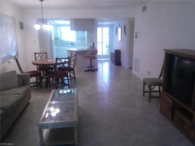 Tiled living room with a notable chandelier and sink