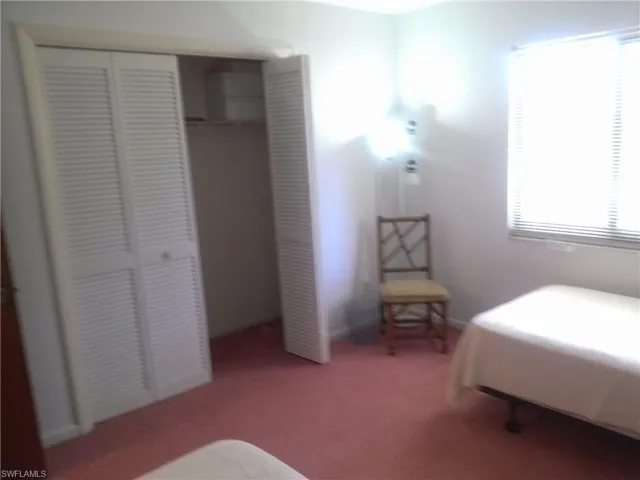 Carpeted bedroom with a closet