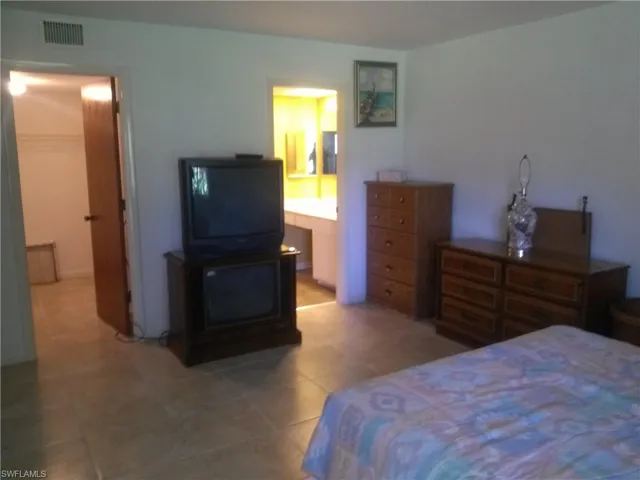 Tiled bedroom with connected bathroom, a closet, and a spacious closet