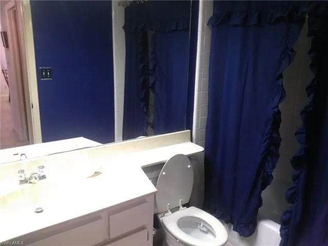 Full bathroom featuring shower / bath combo, vanity, and toilet