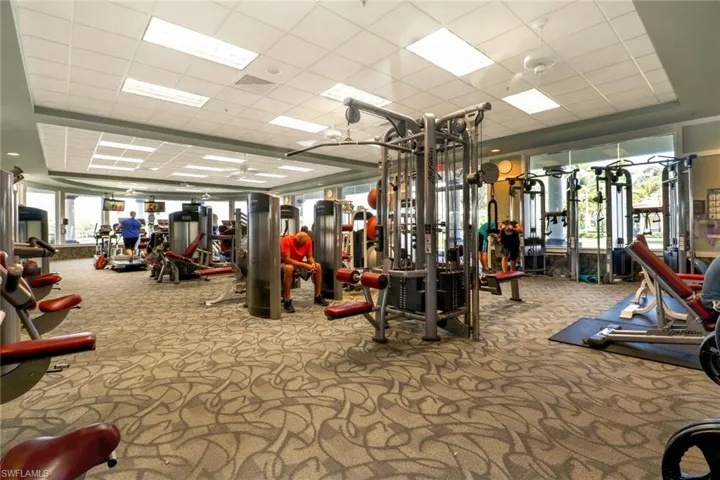 Exercise room with carpet floors and a paneled ceiling