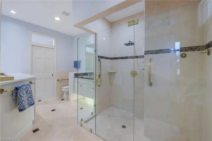 "His" bathroom, located just off the primary bedroom suite. There is a closet behind the door. This bathroom also allows lanai access.