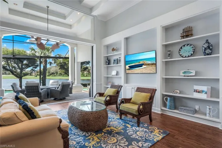 This formal living space overlooks the pool with views of the lake and golf course. Notice the volume ceilings and sliding doors.