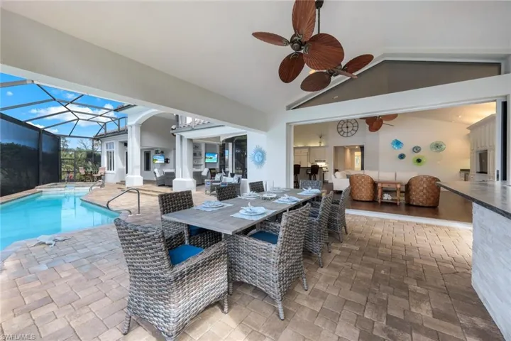 The outdoor living area features a kitchen and bar, with plenty of room to entertain your guests.
