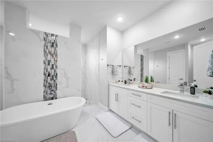 Bathroom featuring vanity and separate shower and tub