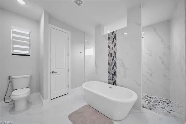 Bathroom featuring separate shower and tub and toilet