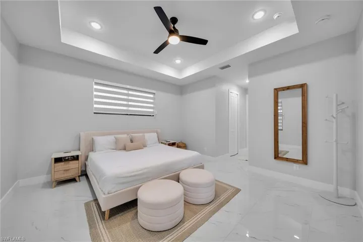 Bedroom featuring ceiling fan and a tray ceiling