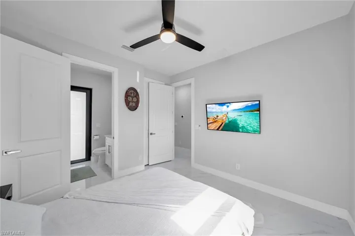 Bedroom featuring ceiling fan and connected bathroom