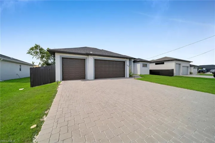 View of front of property with a garage and a front lawn