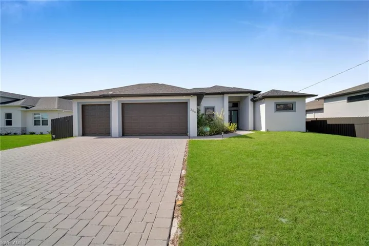 View of front facade with a garage and a front lawn