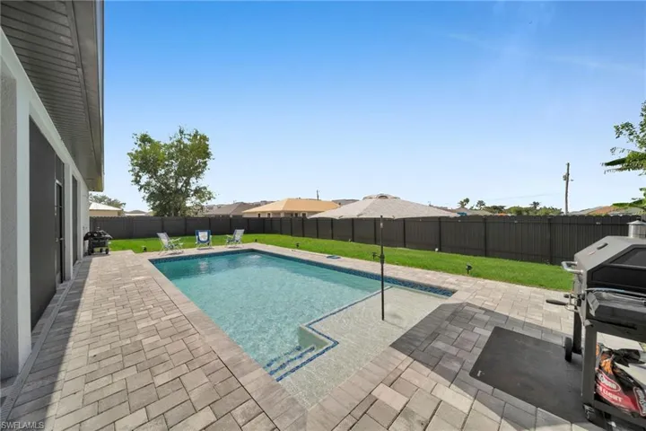 View of pool with a grill, a yard, and a patio area