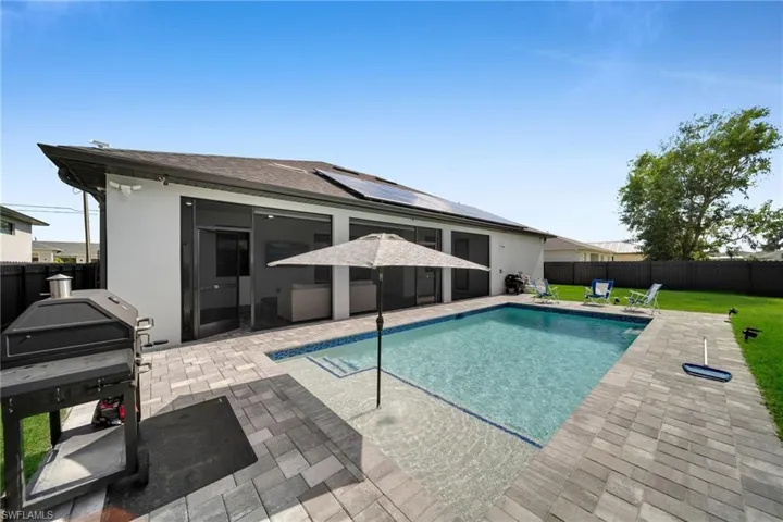 View of swimming pool with a patio area, grilling area, and a lawn