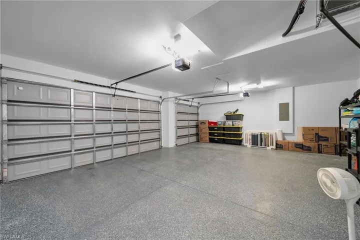 Garage featuring a garage door opener and electric panel