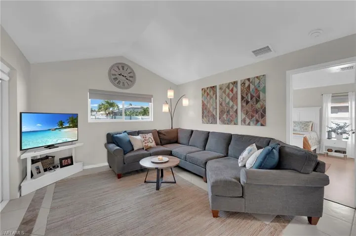 Living area featuring vaulted ceiling and light tile patterned floors