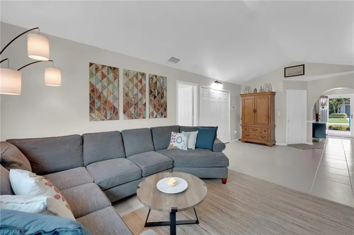 Living area featuring vaulted ceiling and arched walkways