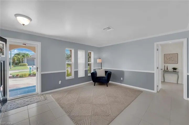 Unfurnished room featuring healthy amount of natural light, tile patterned flooring, and ornamental molding