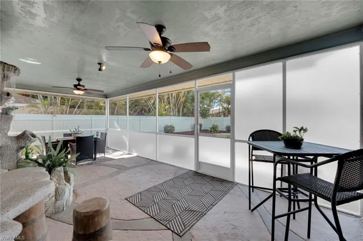 Sunroom / solarium featuring outdoor dining area and a ceiling fan