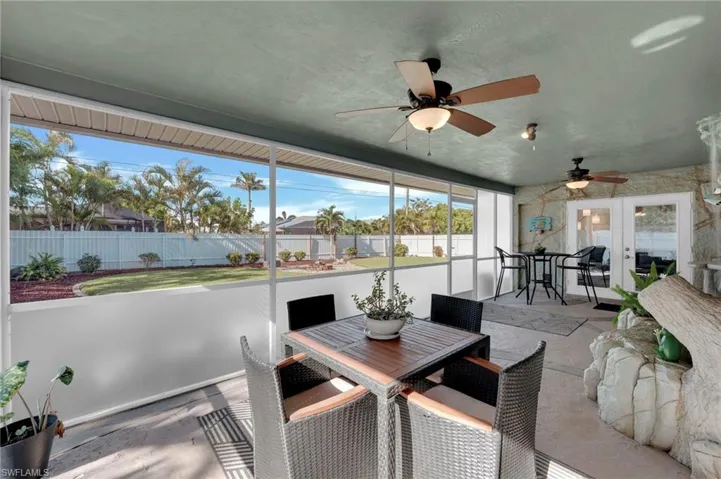 Sunroom featuring outdoor dining space, ceiling fan, and french doors