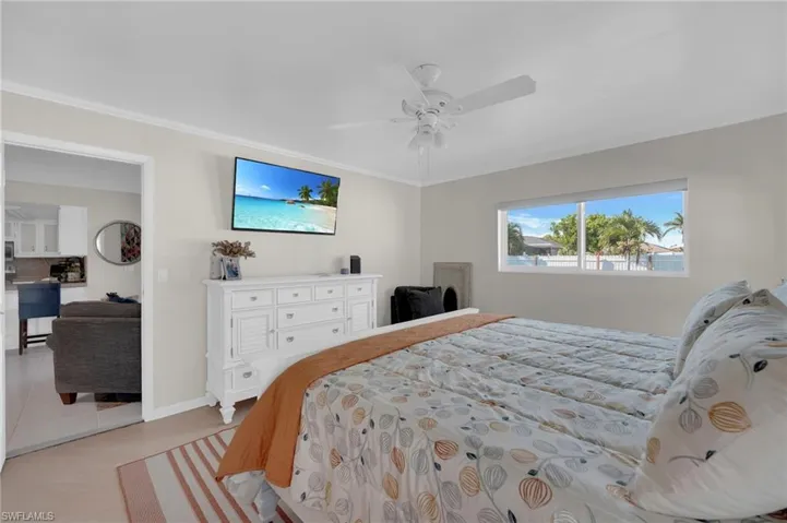 Bedroom featuring ceiling fan, ornamental molding, and light tile patterned floors