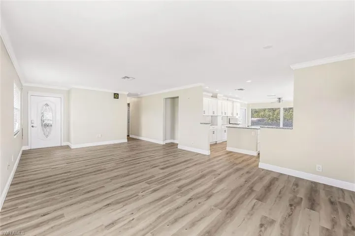 Unfurnished living room featuring crown molding, light hardwood / wood-style flooring, and ceiling fan