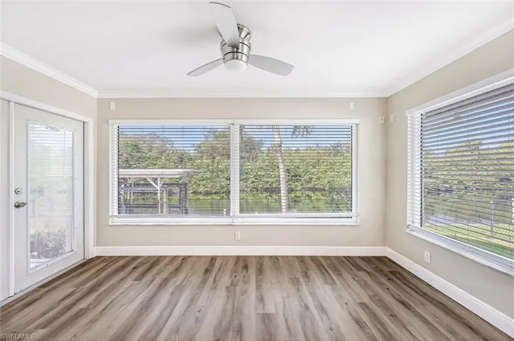 Unfurnished room featuring ceiling fan and a wealth of natural light