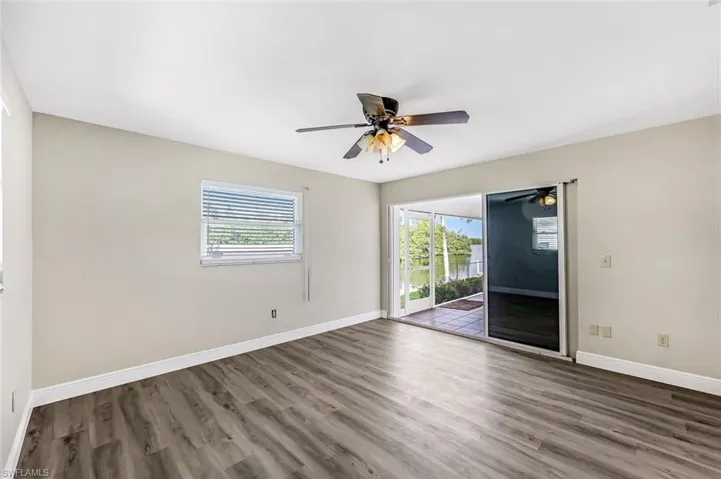 Unfurnished room with ceiling fan and dark wood-type flooring