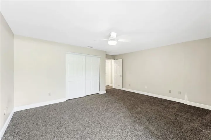 Unfurnished bedroom with carpet, a closet, and ceiling fan