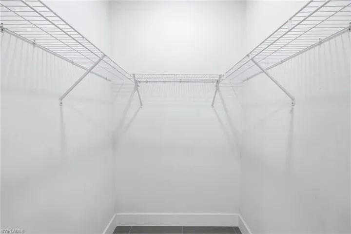 Walk in closet featuring dark tile patterned floors